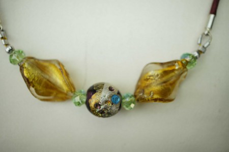 Motif en "Murano" et cristal en harmonie vert et or sur cuir bordeau